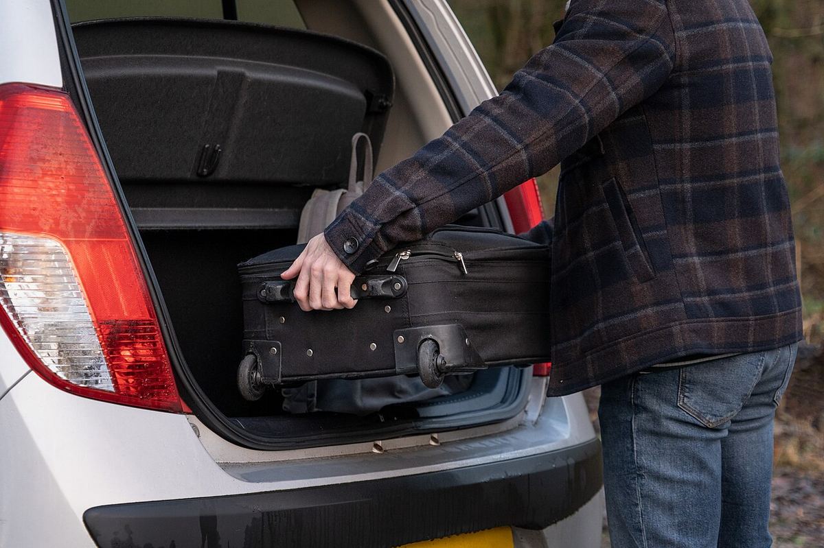 A car boot being packed with suitcases for a long journey, the practical reality of an international move